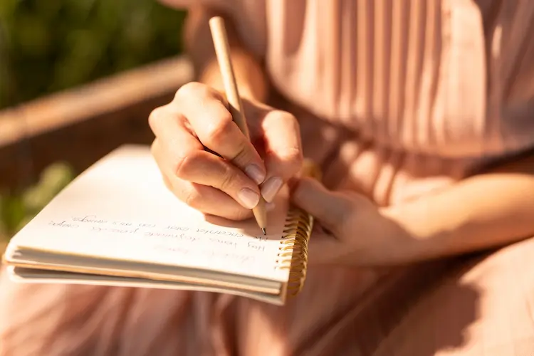 close up hand writing in journal pink dress

live an intentional life
