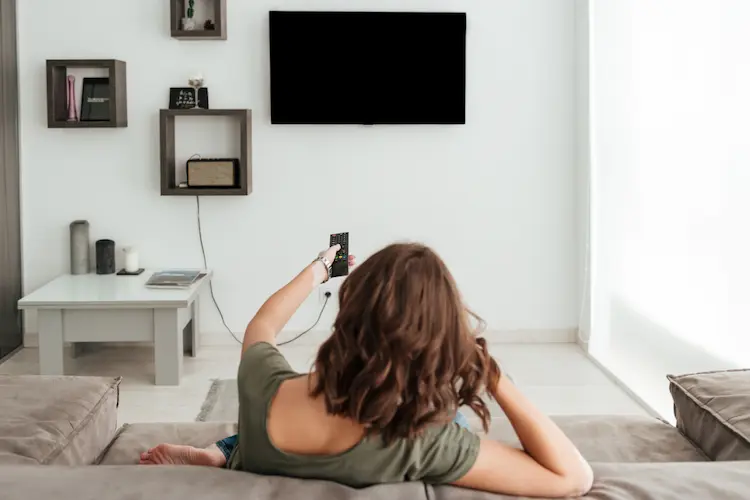 woman turning off tv