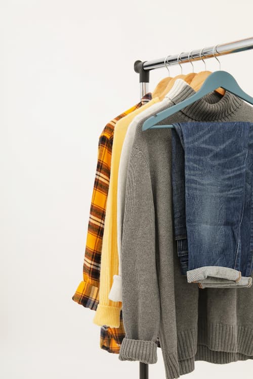 fall clothes hanging on clothing rack white background