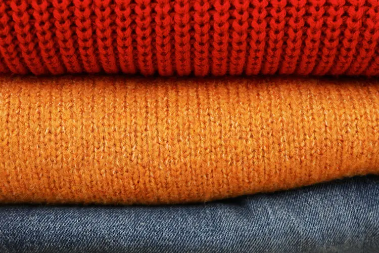 folded autumn sweaters and denim