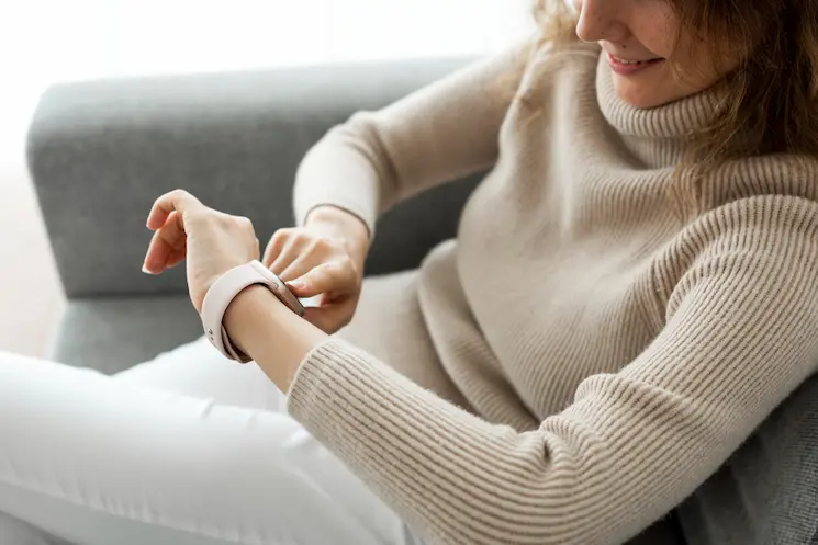 sitting woman looking at fitness watch