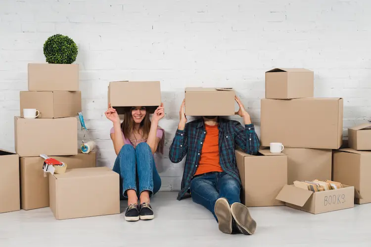 couple moving hiding under boxes