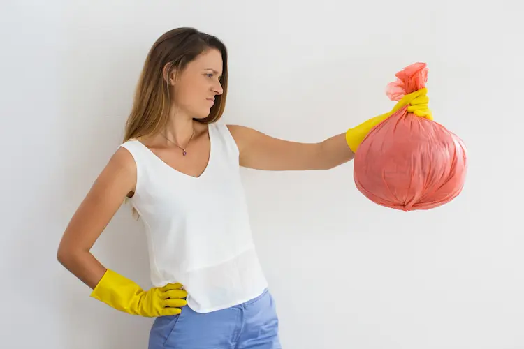 frowning young woman with trash bag