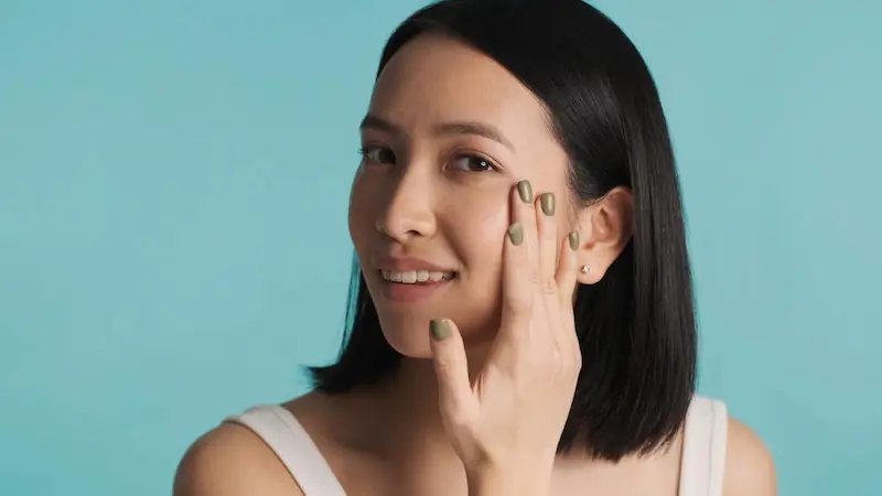 woman putting on makeup or face lotion