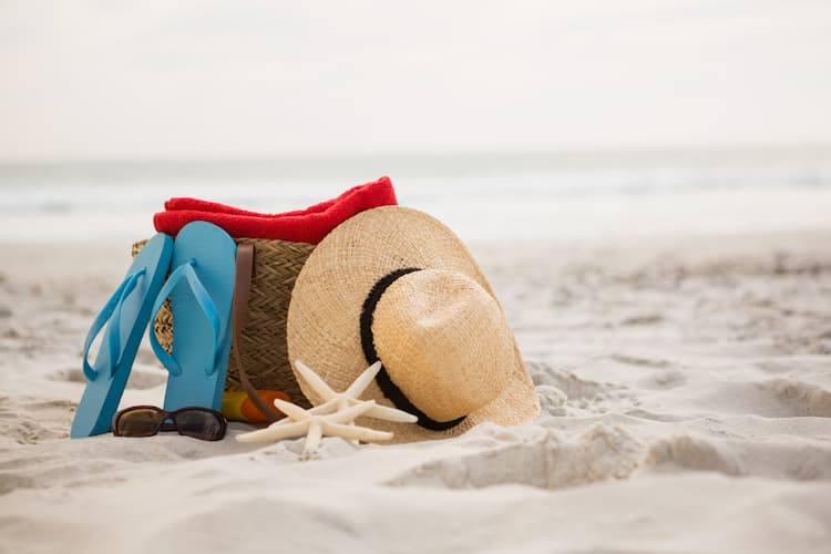 beach bag flip flops hat towel starfish on beach