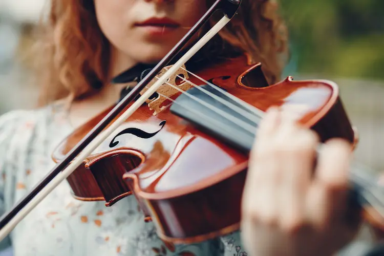 girl playing violin outside