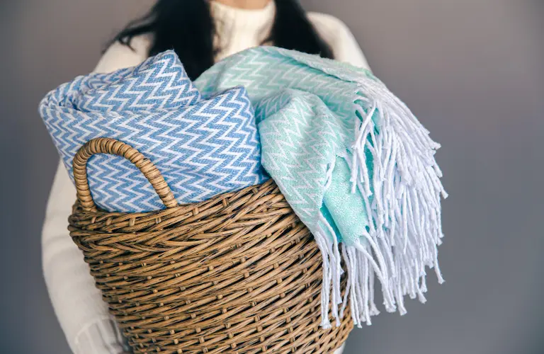 woman holding basket with throw blankets

tidy home tips