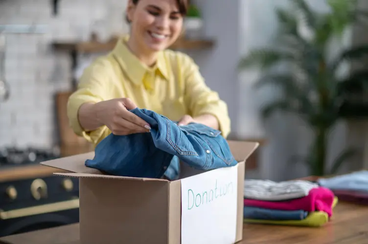 woman putting clothes in box to donate
declutter goals
