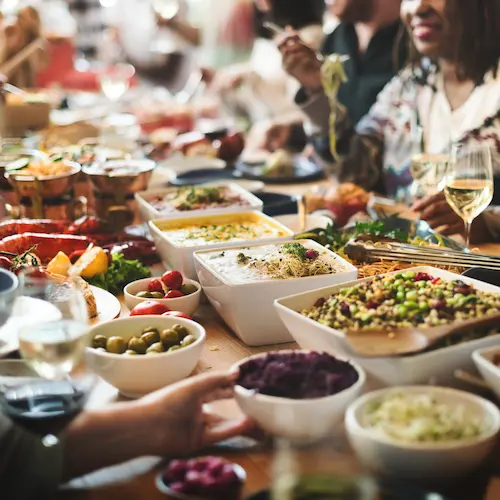 lots of food people eating around table