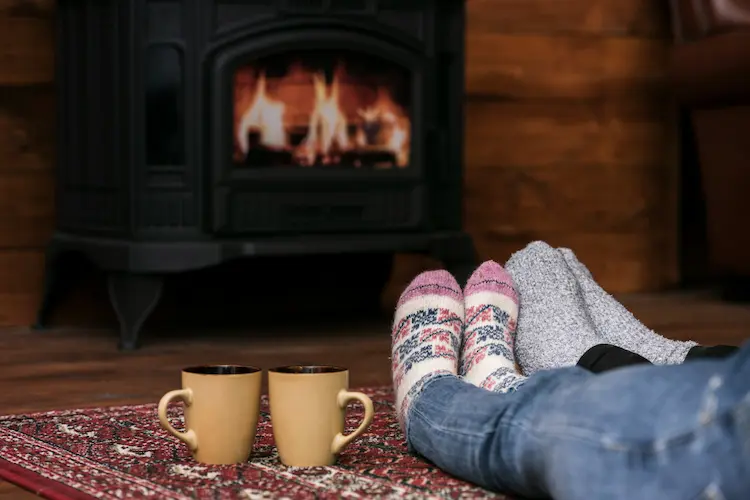 couple with socks warming feat by fire