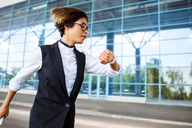 young proffessional woman running looking at watch