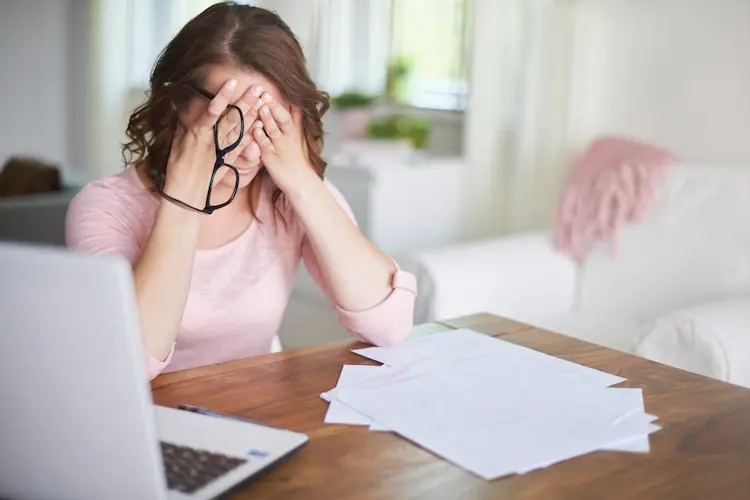 frustrated woman hands on head at computer 