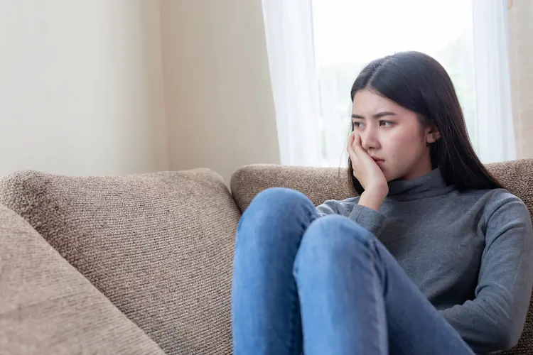 woman sad on couch thinking