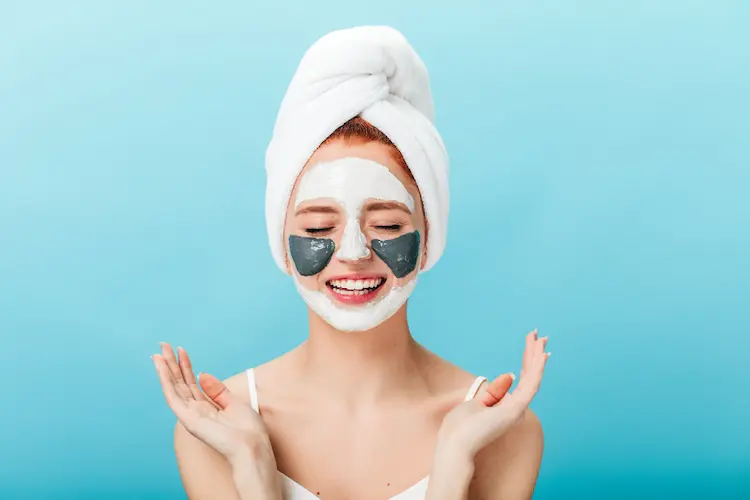 woman with face mask and towel on head self care