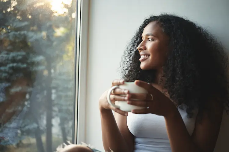 young black woman having coffee by window

decluttering changed my life
