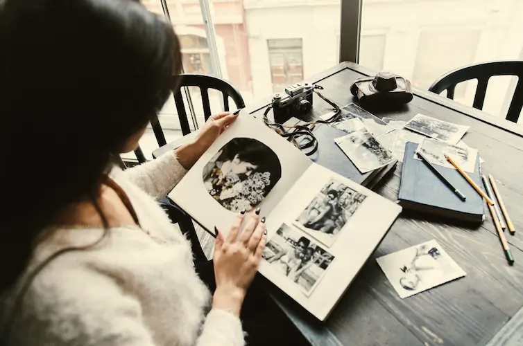 woman looking at black and white photo album