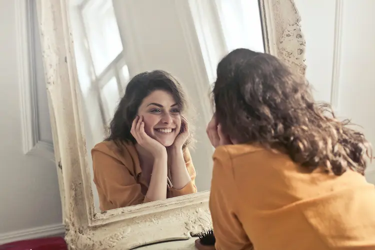 happy woman looking in mirror