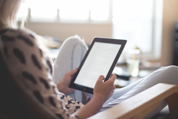 woman sitting reading e reader
