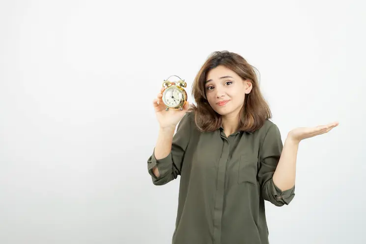 confused woman holding clock hands up poor time management