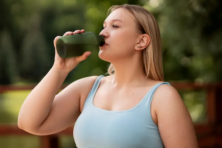 woman drinking bottled water