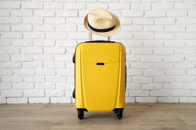 yellow suitcase with hat on top
minimalist vacation tips