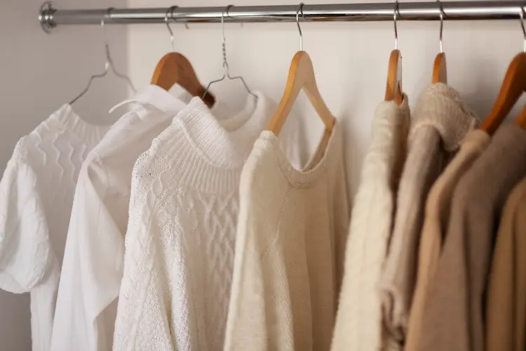 white and tan clothing hanging in closet
