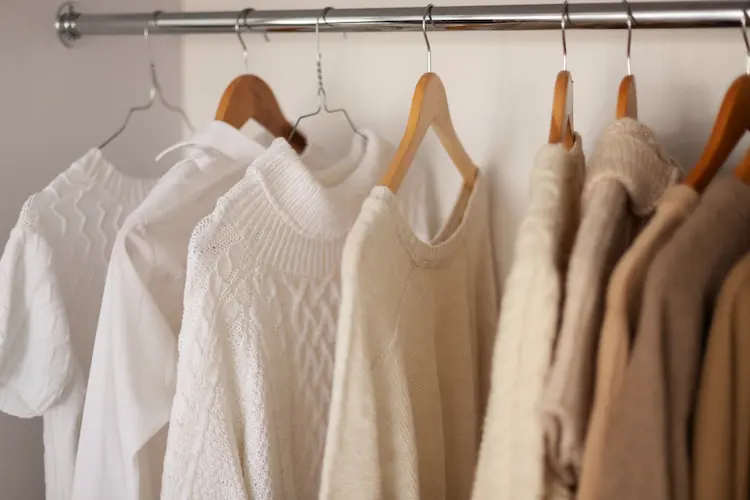 white and tan clothing hanging in closet
living with less clothing 