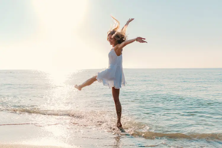 happy woman dancing on beach