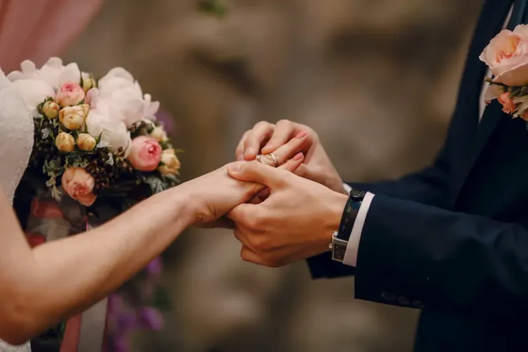 groom putting ring on brides finger