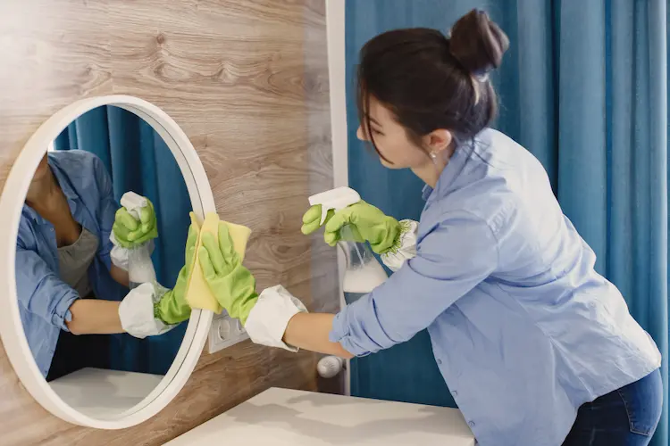 woman cleaning mirror