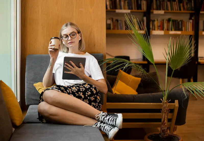 woman reading with coffee on couch